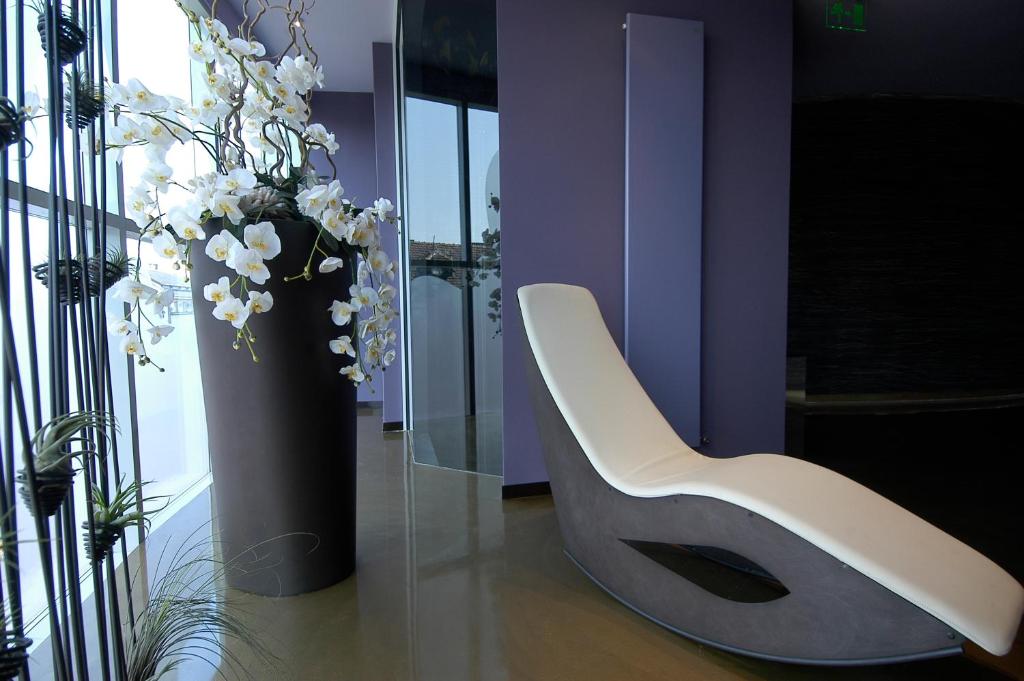a white chair in a room with a vase of flowers at Les Fleurs Boutique Hotel in Sofia