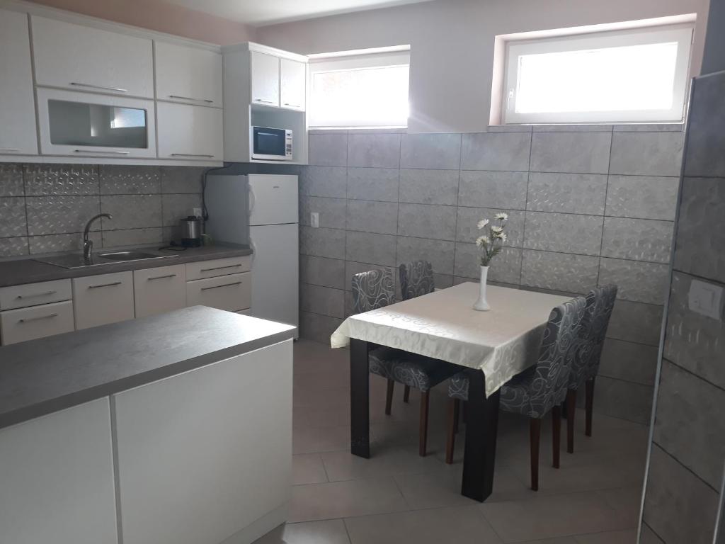 a kitchen with a table with a vase of flowers on it at Andi Apartman in Pačir