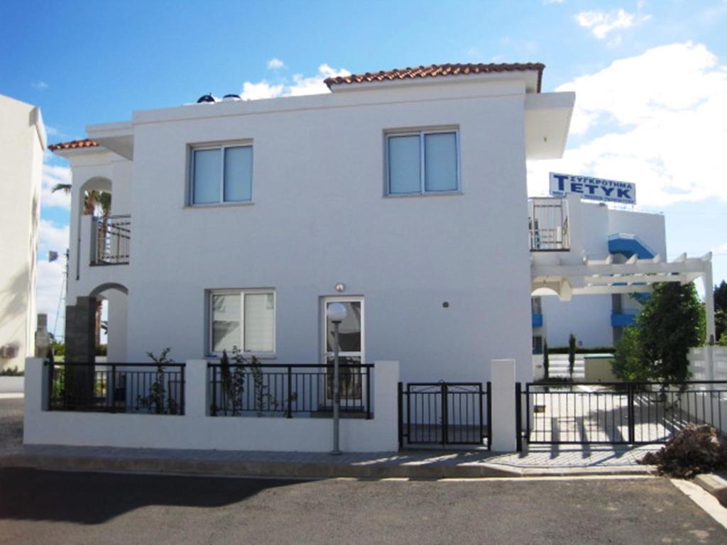 a white house with a black fence in front of it at Polyxenia Isaak Pelagos Villa in Protaras