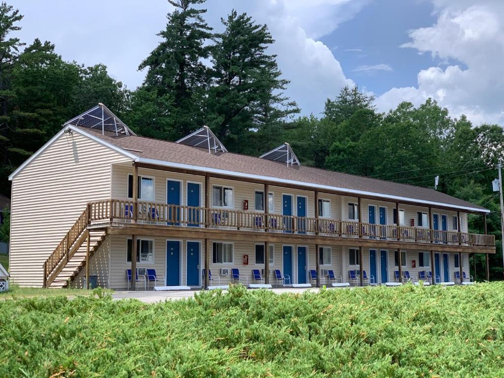 a large house with blue doors and a deck at Travelodge by Wyndham Lake George NY in Lake George