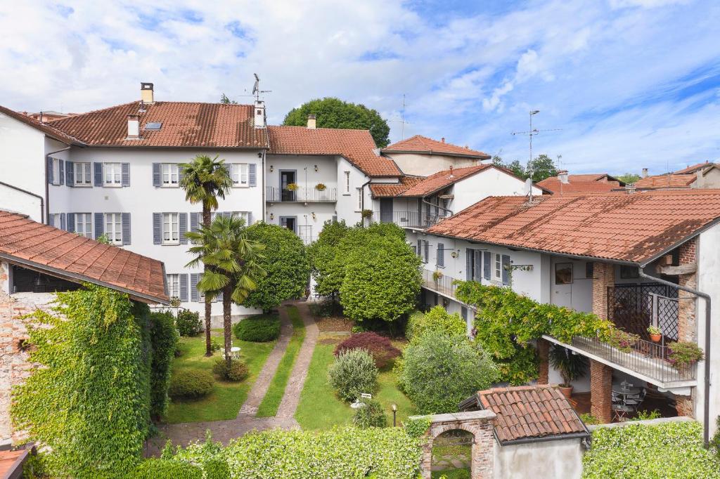 un grupo de edificios blancos con árboles y arbustos en Antica Casa Balsari, en Borgo Ticino