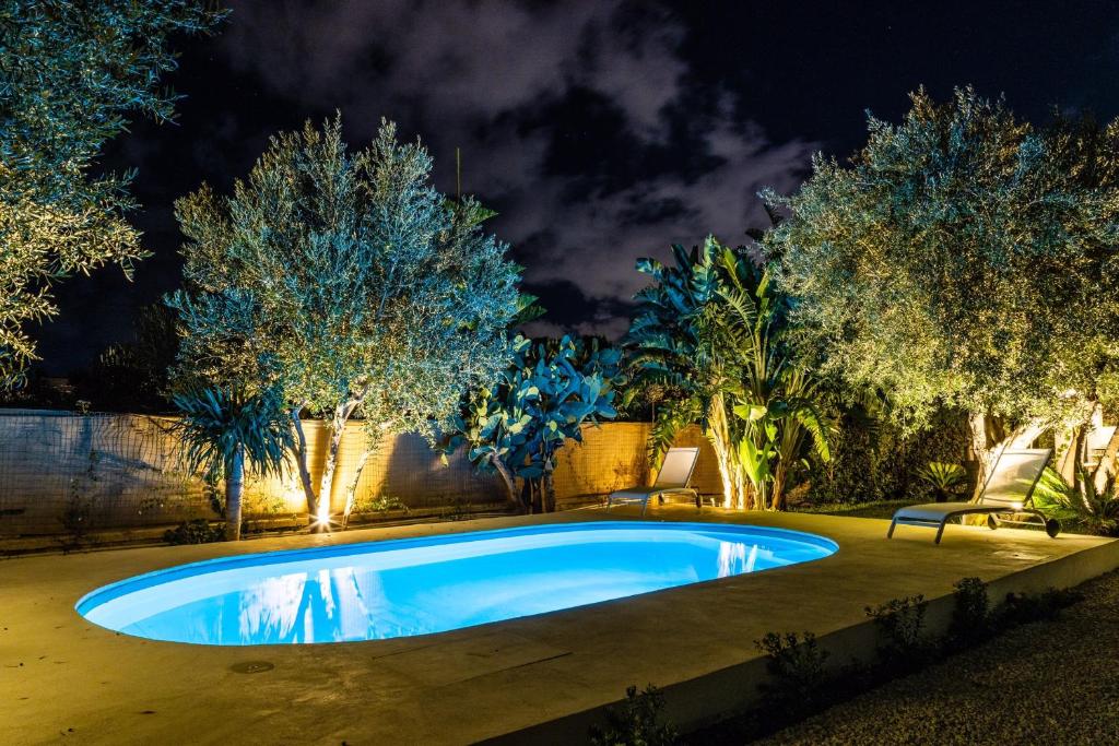 - une piscine dans une cour arborée la nuit dans l'établissement Villa Bienvenue, à Carini