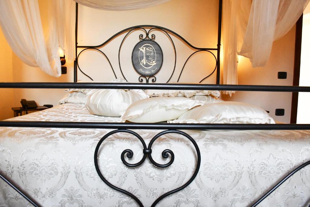a bed with a black and white bed frame and pillows at Grand Relais Laurenti in Gualdo Cattaneo