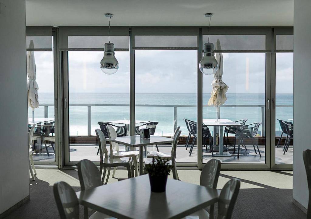 a room with tables and chairs and a view of the ocean at Arribas Sintra Hotel in Sintra
