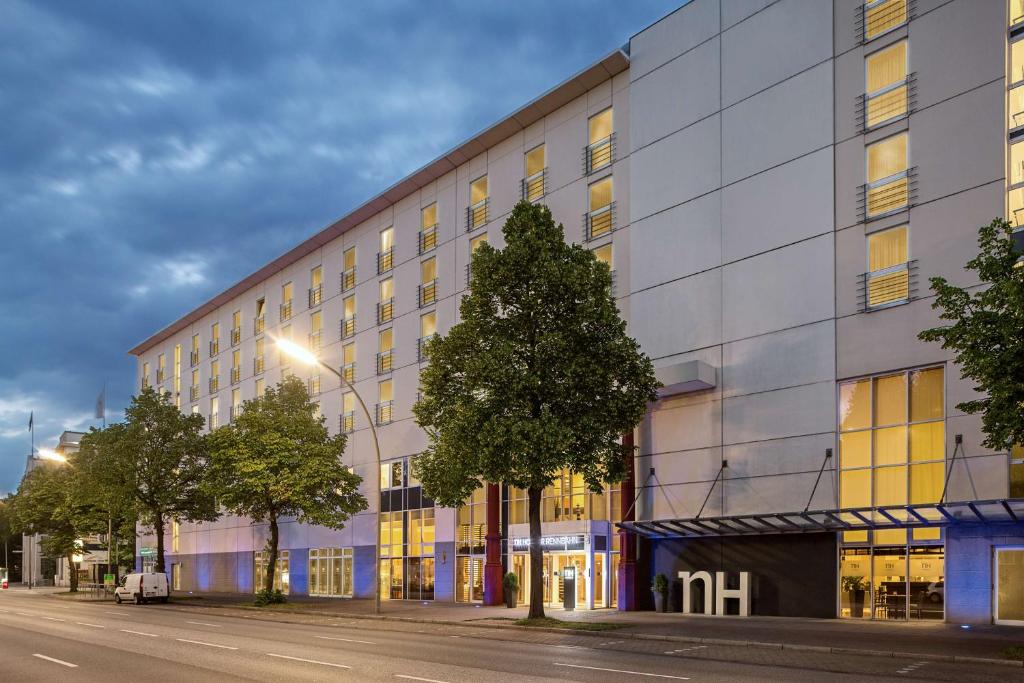 a building on a street with a tree in front at NH Hamburg Horner Rennbahn in Hamburg