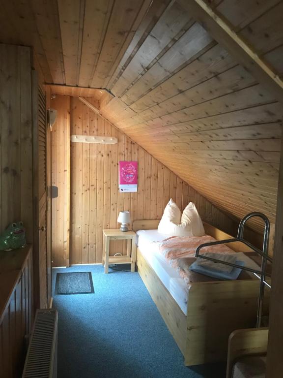 um quarto com uma cama num sótão de madeira em Ferienwohnung Gürth em Kleinhennersdorf