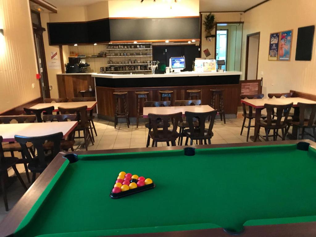 een pooltafel in een restaurant met tafels en stoelen bij hotel de la gare in Verchamp