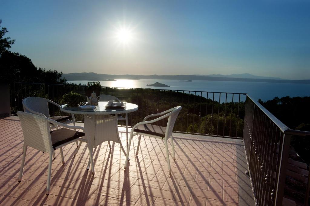 a patio with a table and chairs on a balcony at Agriturismo Specchio Del Lago in Montefiascone