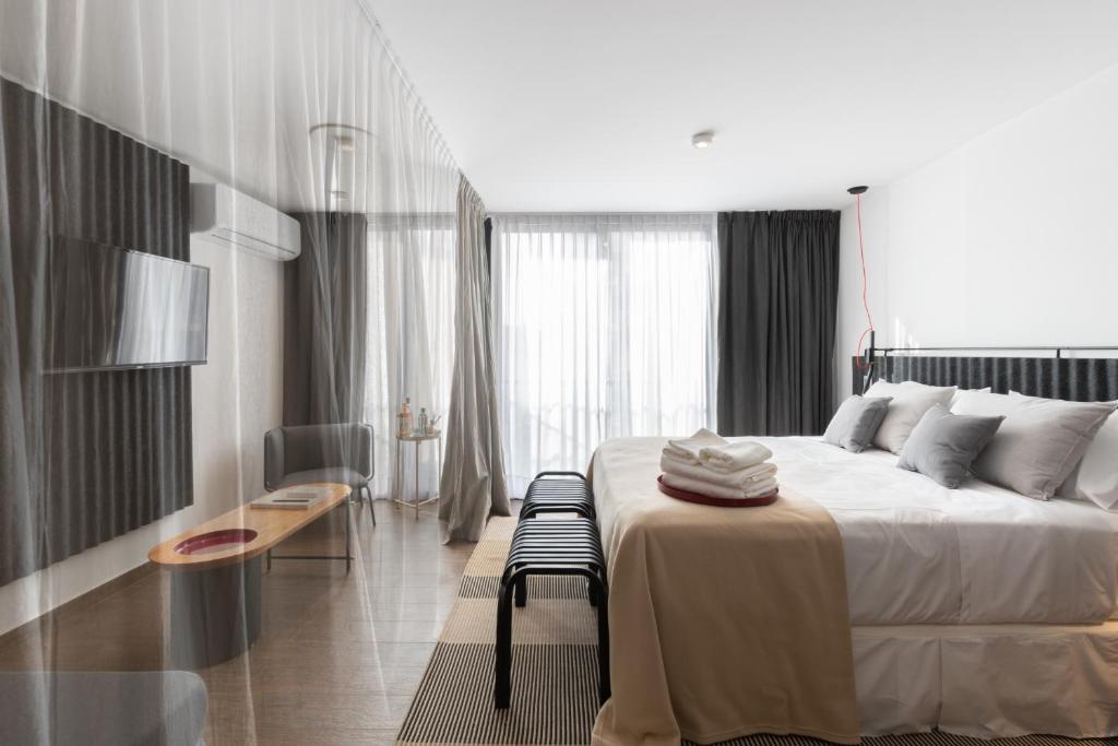 a bedroom with a large bed with a table and a chair at Stay Suites in Cordoba