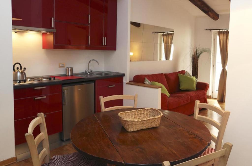 cocina y sala de estar con mesa y sofá en San Teodoro Apartment en Roma
