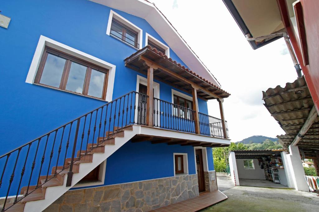 un bâtiment bleu avec des escaliers et un balcon. dans l'établissement La casina de ribadesella 5 personas, à Ribadesella