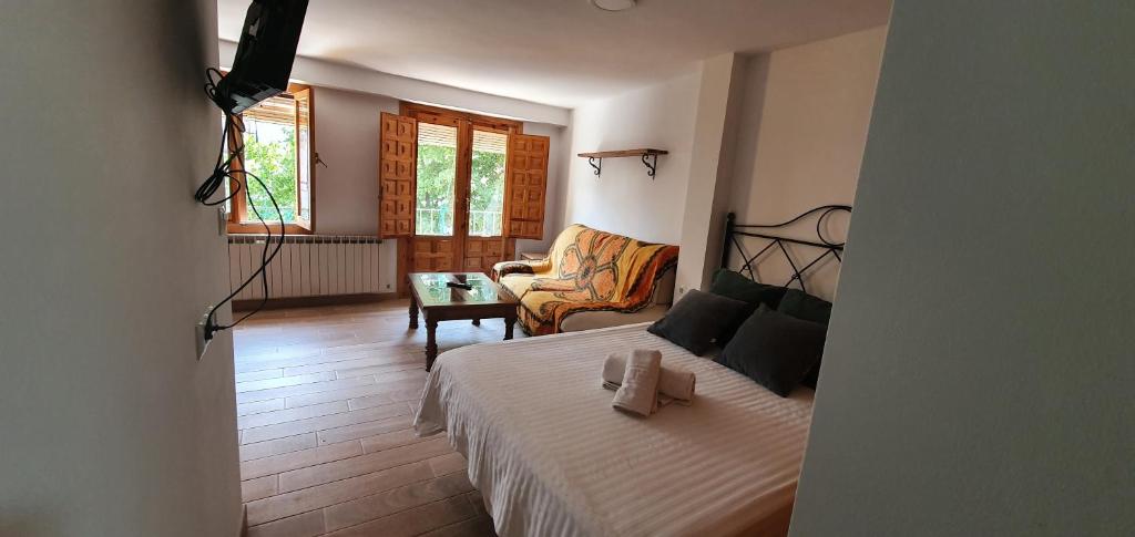 1 dormitorio con 1 cama y sala de estar en Apartamentos Casa Botes II, en Cuenca