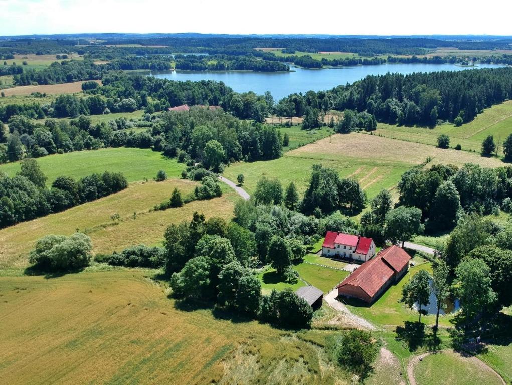 uma vista aérea de uma quinta com um celeiro e um lago em Folwark Mazurskie Legendy - Azyl dla Dorosłych em Kruklanki