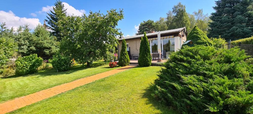 una casa con jardín y césped con árboles en Ferienhaus am Birkenwaeldchen - Motzener See 150m en Mittenwalde