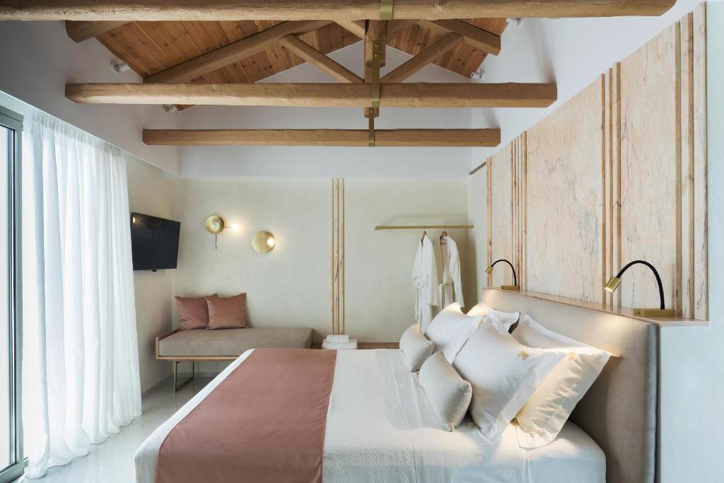 ein Schlafzimmer mit einem großen weißen Bett und einem Sofa in der Unterkunft Mirabile Luxury Suites in Chania