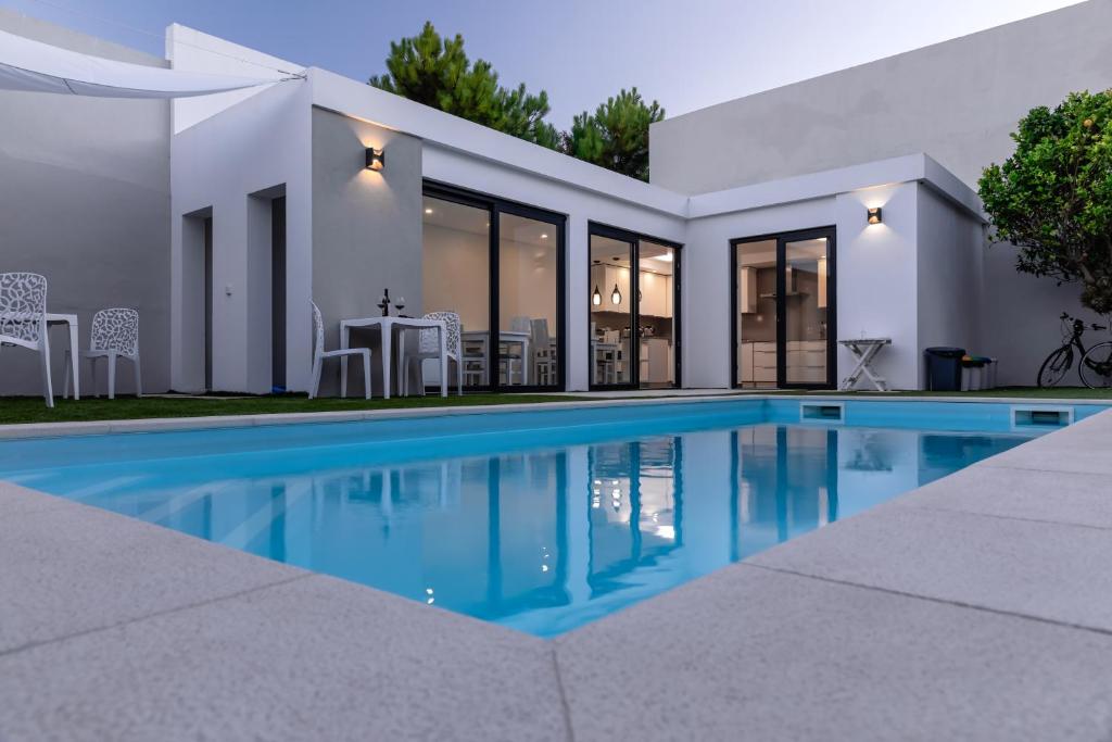 a swimming pool in front of a house at Ilheu 25 Peniche House in Peniche