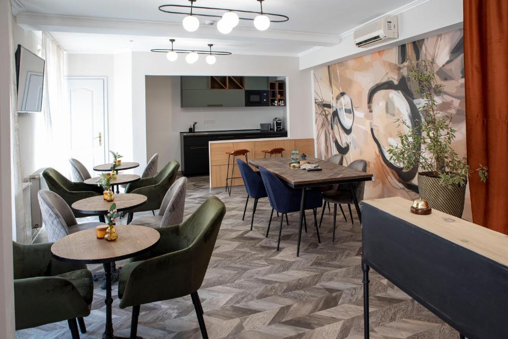 um restaurante com mesas e cadeiras num quarto em Duett - Urban Rooms em Gyor