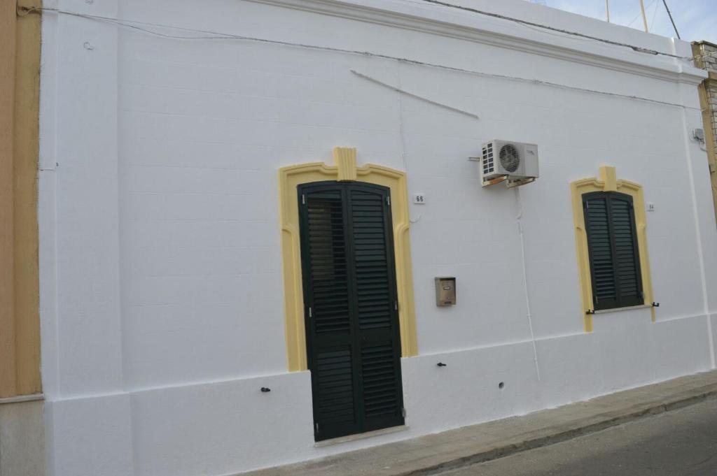 a white wall with two green shutters on it at CASA DEBORAH in Alliste