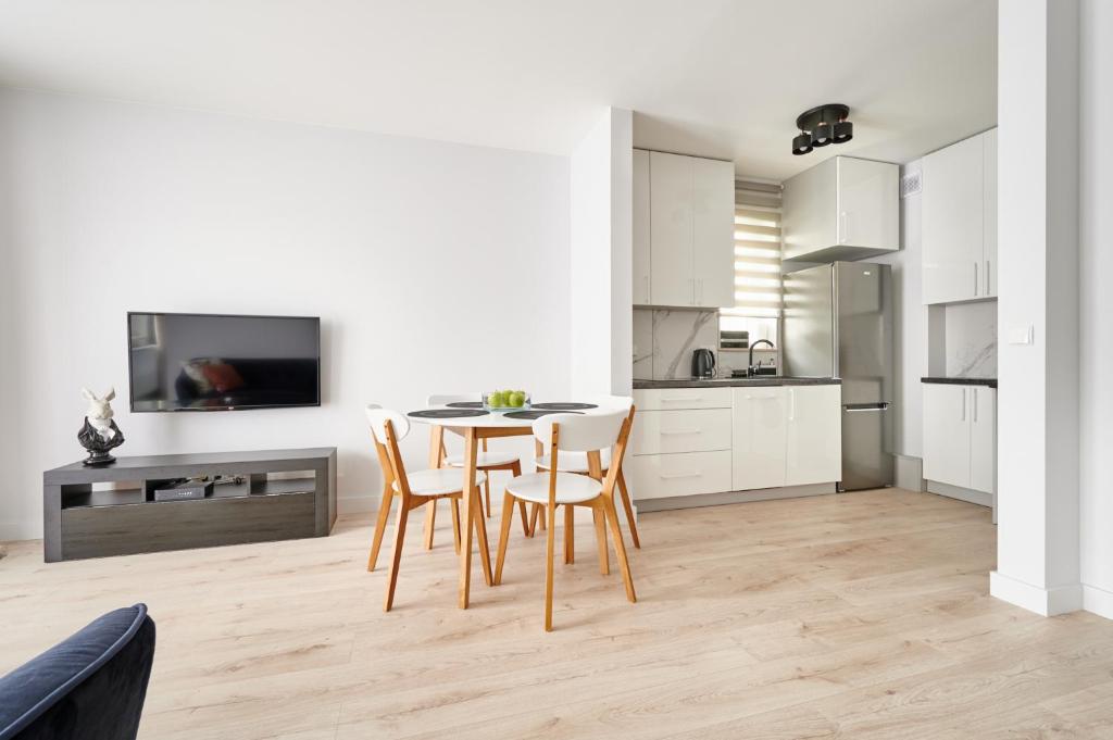 奥尔什丁Apartament Dwa Jeziora的房间里有一张桌子和几把椅子的厨房