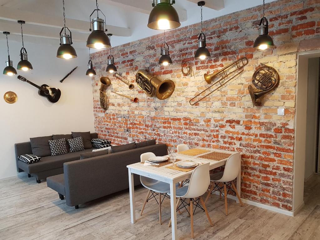 a dining room with a brick wall and a table and chairs at Art Music Loft Białystok in Białystok