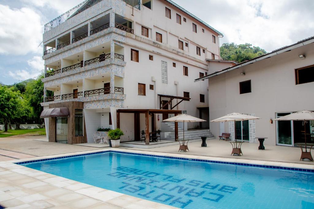 un hotel con piscina di fronte a un edificio di HOTEL CANTINHO DAS FLORES a Guaramiranga