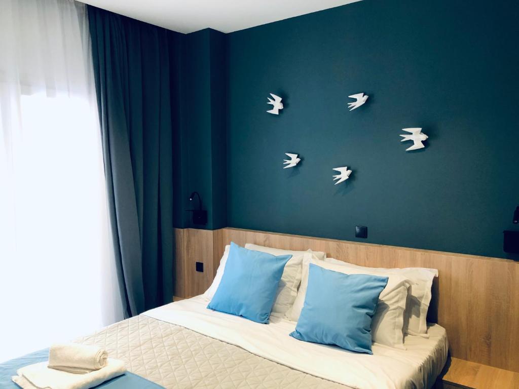 - une chambre avec un lit aux murs bleus et aux papillons blancs dans l'établissement Metropolitan Complex budget room@Faliro, au Pirée