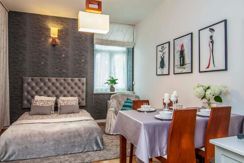 jadalnia ze stołem i łóżkiem oraz stołem i krzesłami w obiekcie Apartament 2 pokoje Lublin Centrum ulica Narutowicza w mieście Lublin