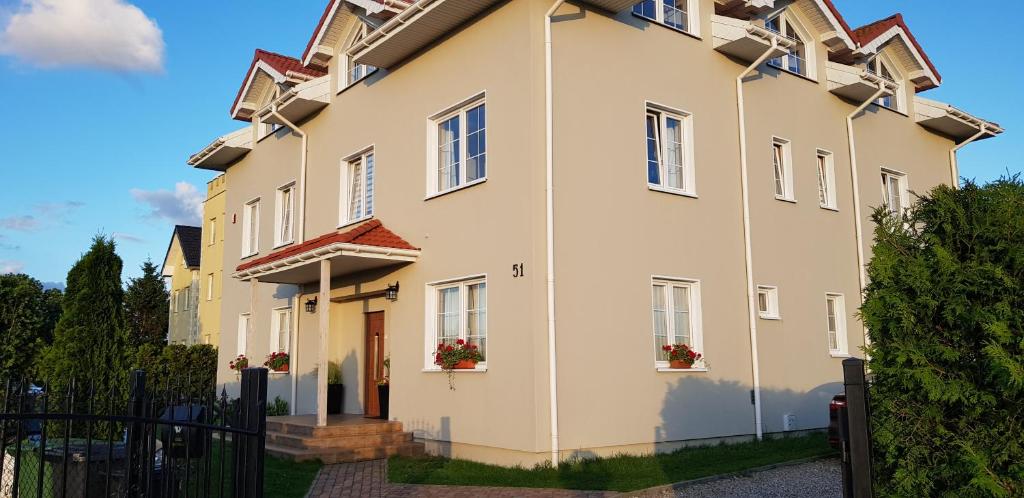 a large white house with a black fence at Kwatery Mielenko Patraj in Mielenko