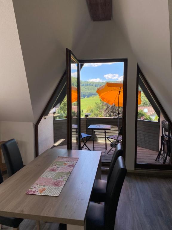 a dining room with a table and an umbrella at Am Irrenbächle in Albstadt