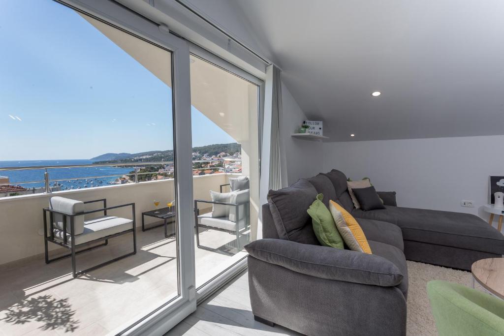 a living room with a couch and a balcony at Golden View Penthouse in Hvar