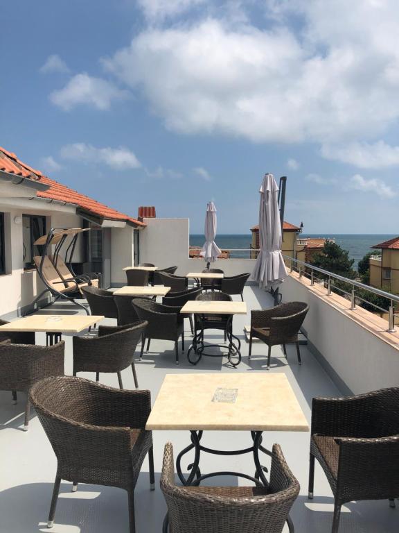 - un ensemble de tables et de chaises sur un balcon donnant sur l'océan dans l'établissement Panoramic, à Eforie Sud