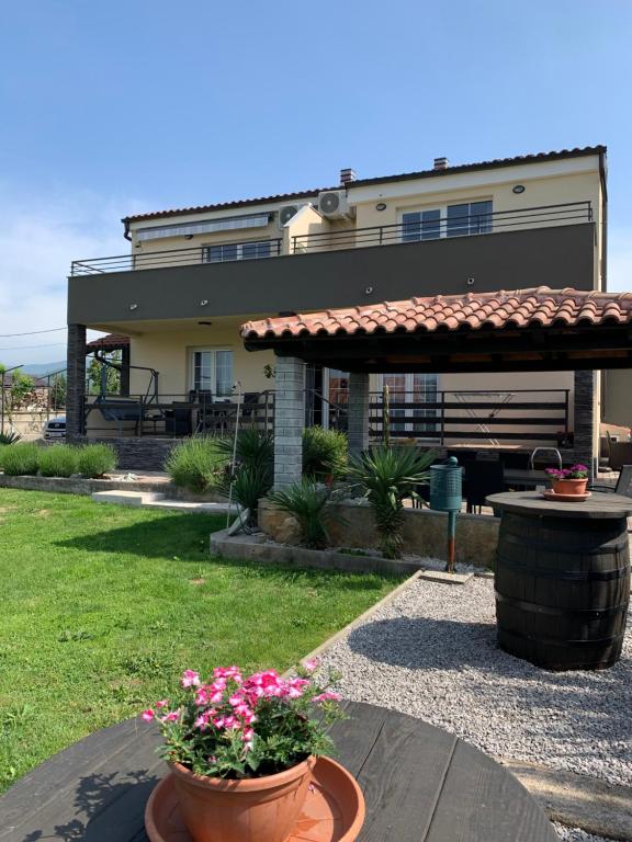 a house with a patio with flowers in front of it at Casa Laura in Rijeka