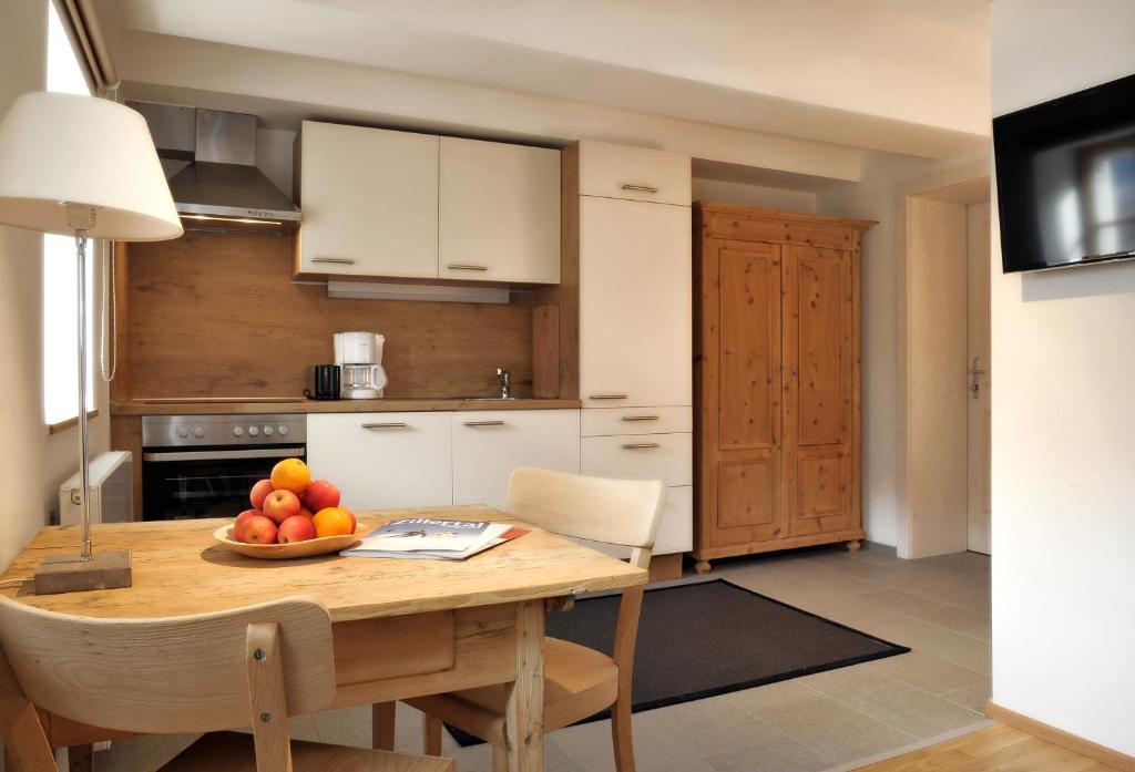 una cocina con una mesa de madera y un bol de fruta. en Apartment Nester, en Stumm