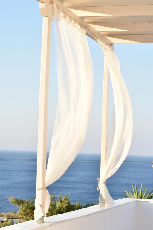 a white gazebo with a view of the ocean at Litus Studios in Megas Yialos-Nites