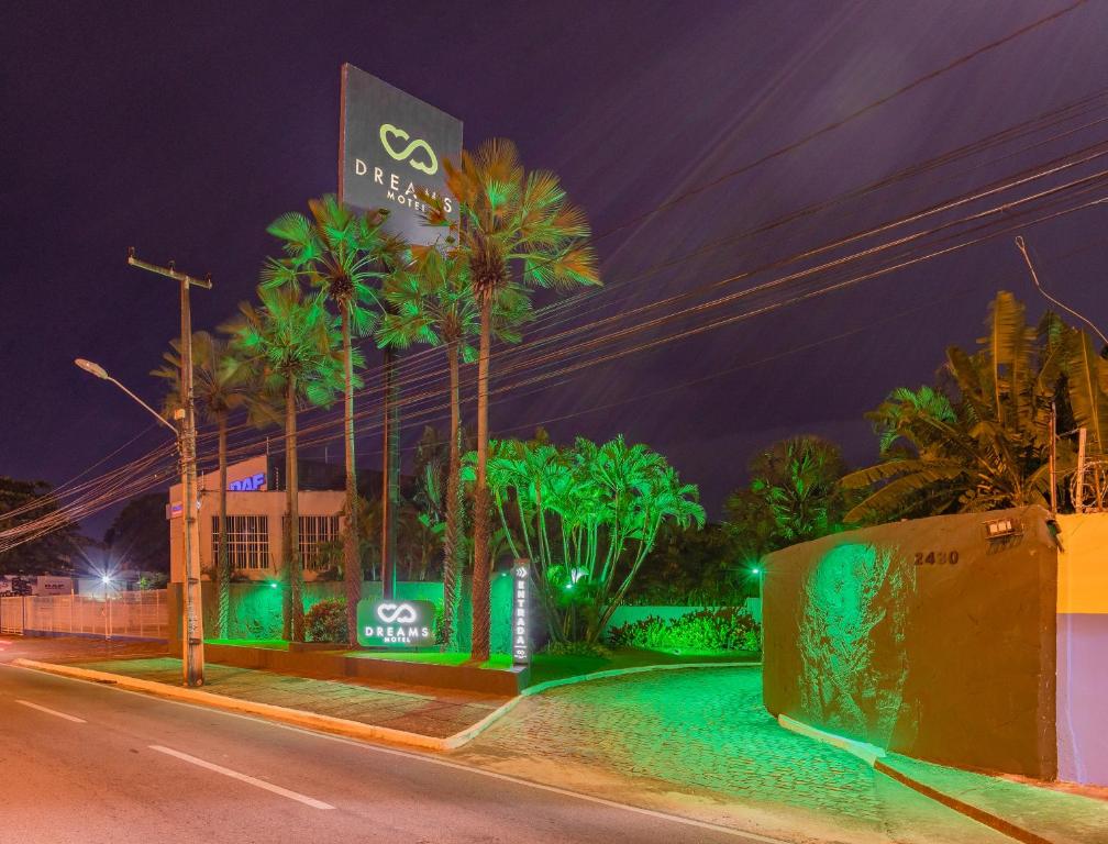 a night view of a hotel with palm trees at Dreams Motel (Adult Only) in Fortaleza