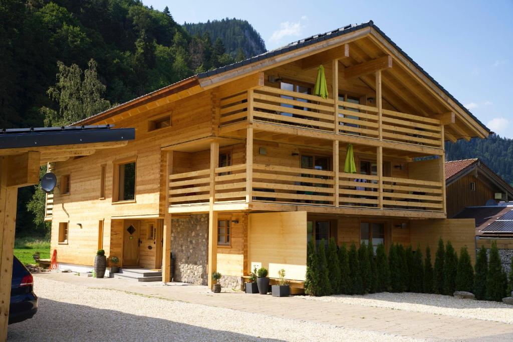 a large wooden building with balconies on the side of it at Leos Alpenchalet - inclusive Sommer Bergbahnticket und E-Auto Ladestation in Oberstdorf