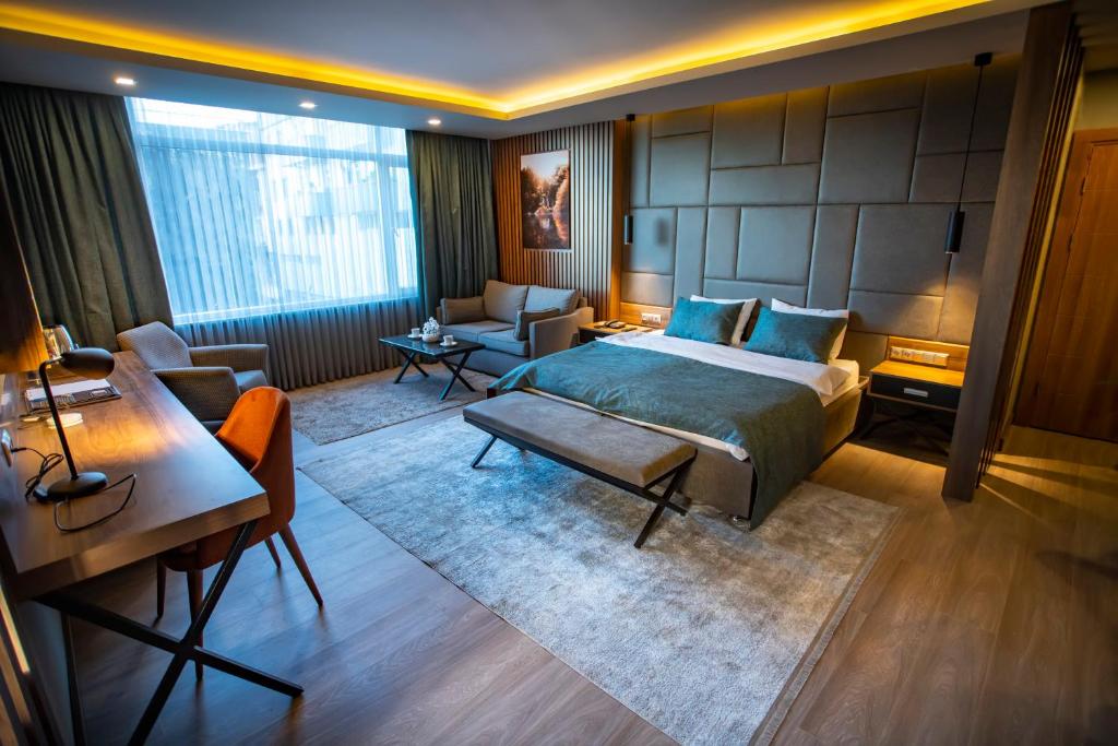 a bedroom with a bed and a desk and a couch at Nova Suite Residence in Trabzon