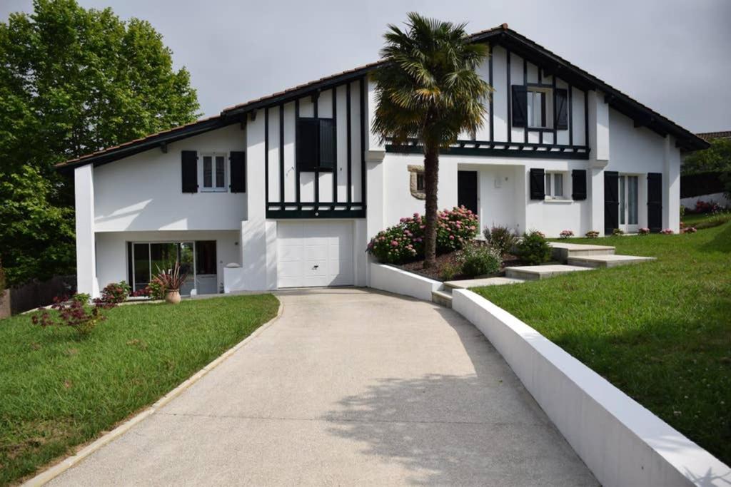 une maison blanche avec un palmier devant dans l'établissement Dokaetchea, à Urrugne