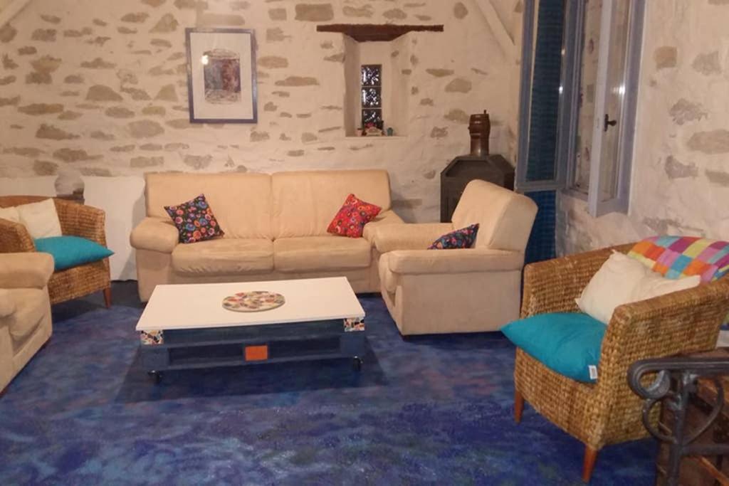 a living room with a couch and chairs and a table at VITIcoloris - Remise Viticole in Pépieux