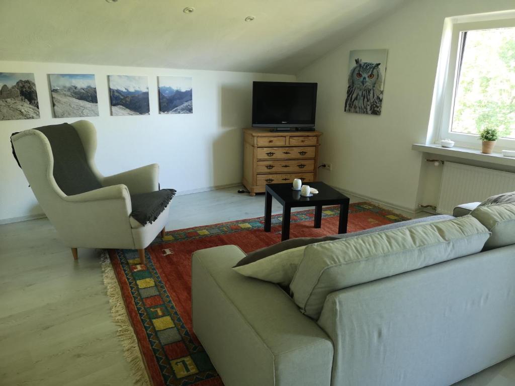 a living room with a couch and a chair and a television at Ferienwohnung "In de Ühl" in Hürtgenwald