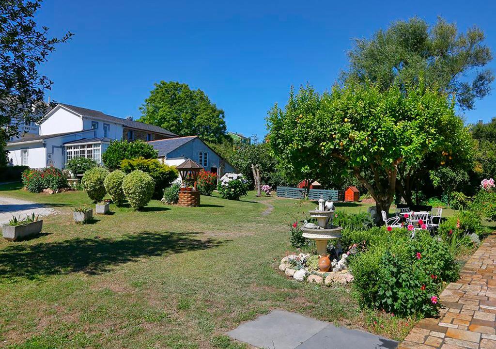 a yard with a house and some bushes and trees at Casa Elena Turismo Rural in Reinante