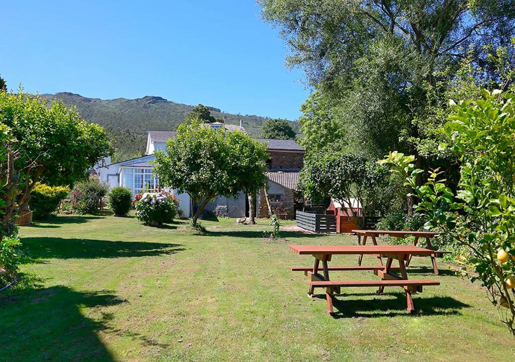a picnic table in a yard with trees and houses at Casa Elena Turismo Rural in Reinante