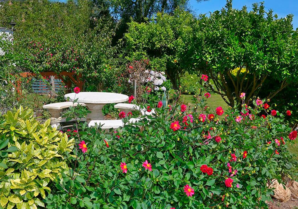 a garden with a bench in the middle of flowers at Casa Elena Turismo Rural in Reinante