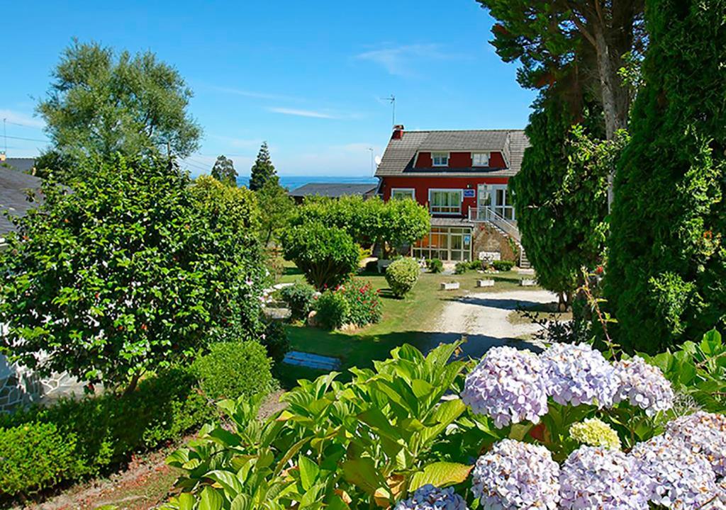 a house with a garden with flowers in front of it at Pensión Casa Elena in Reinante