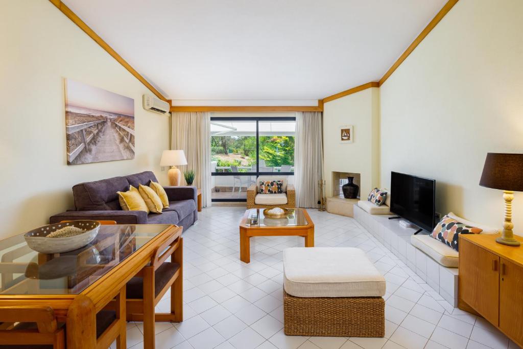 a living room with a couch and a tv at Victory Village T1 & Rooftop terrace in Quinta do Lago