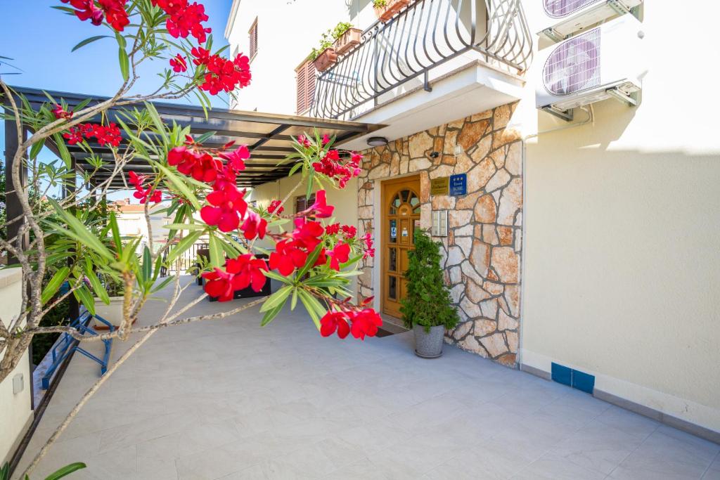 un patio de una casa con flores rojas en Villa Confort Exclusive, en Rovinj