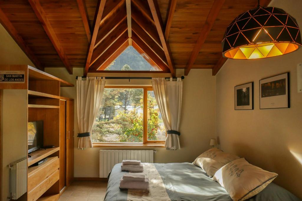 1 dormitorio con cama y ventana grande en Departamento Roca II - ubicacion perfecta en San Martín de los Andes