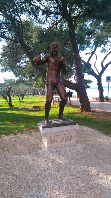 a bronze statue of a man in a park at Haus Milan AP 1 in Fažana