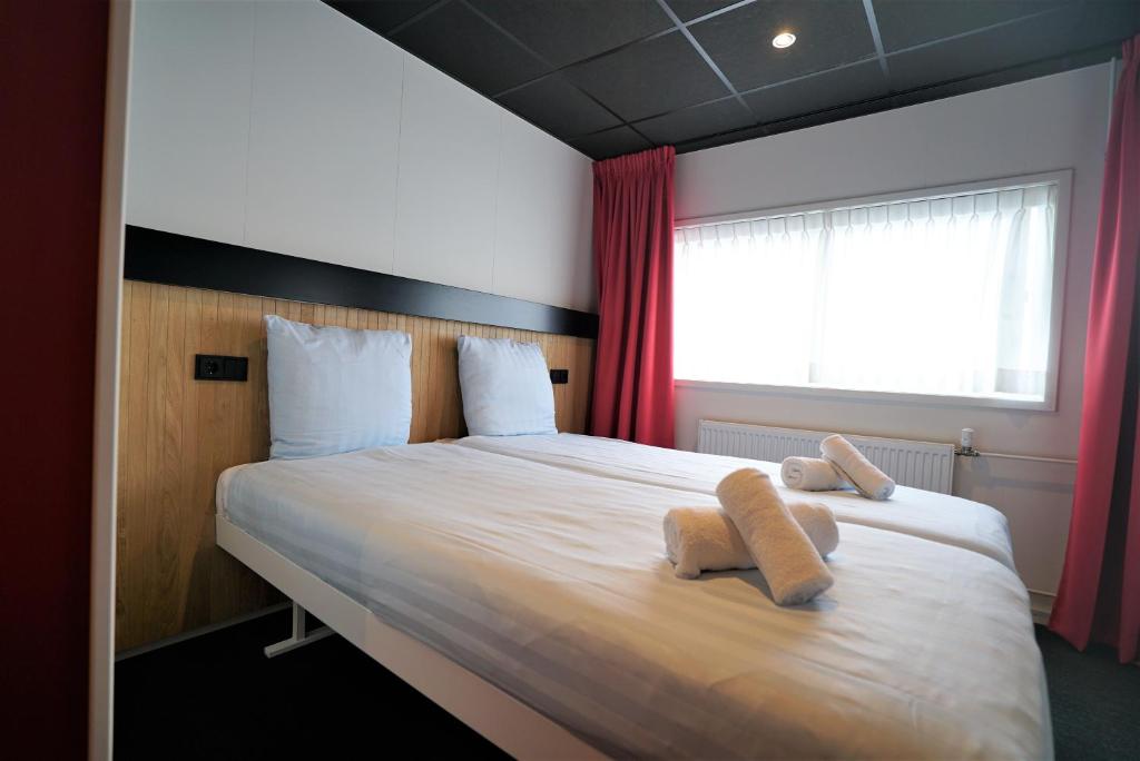 a bedroom with a large bed with two towels on it at Botel in Amsterdam