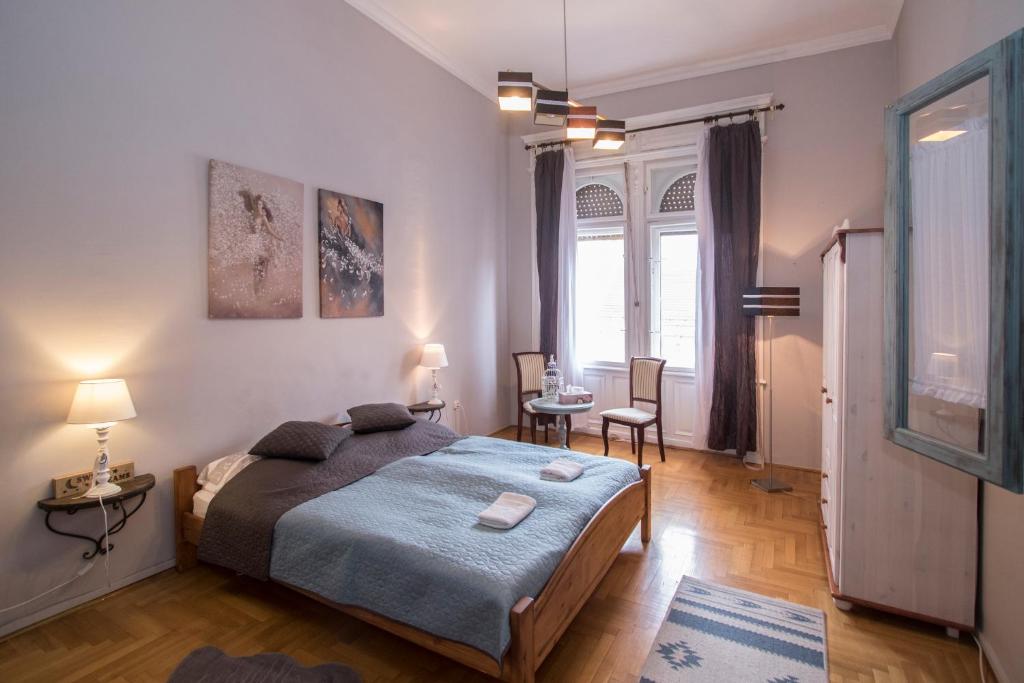 a bedroom with a bed and a table and chairs at Belvárosi Vintage Apartman a sétálóutcán in Miskolc